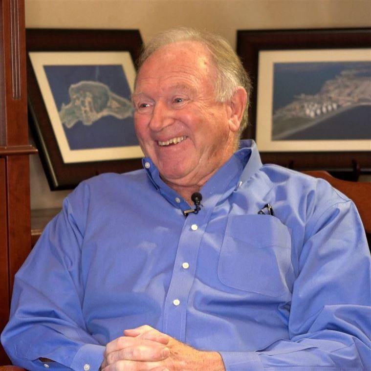 Dick Fox in blue shirt sitting in chair