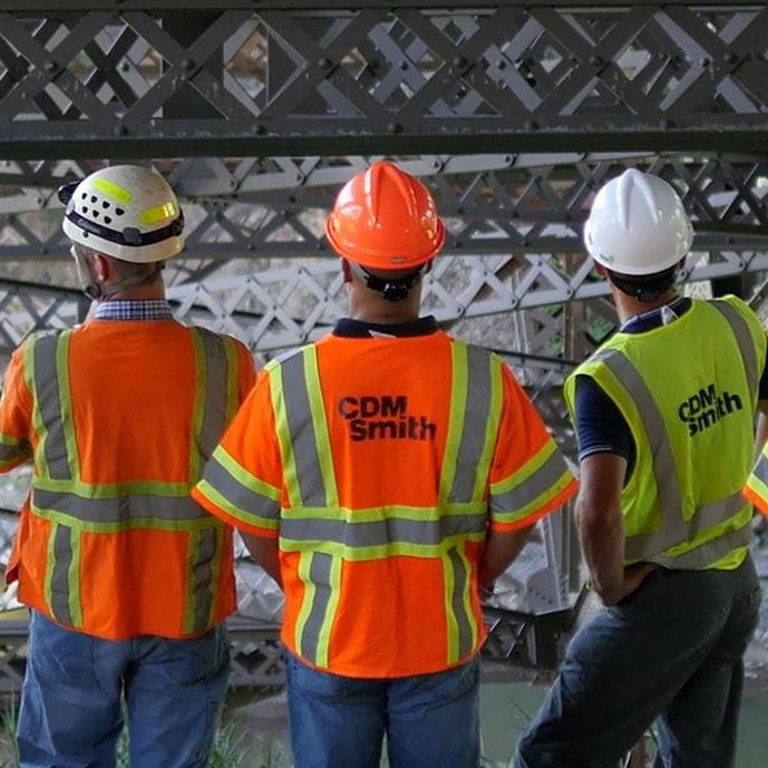 Five construction field staff, including CDM Smith employees, evaluating the underside of a bridge