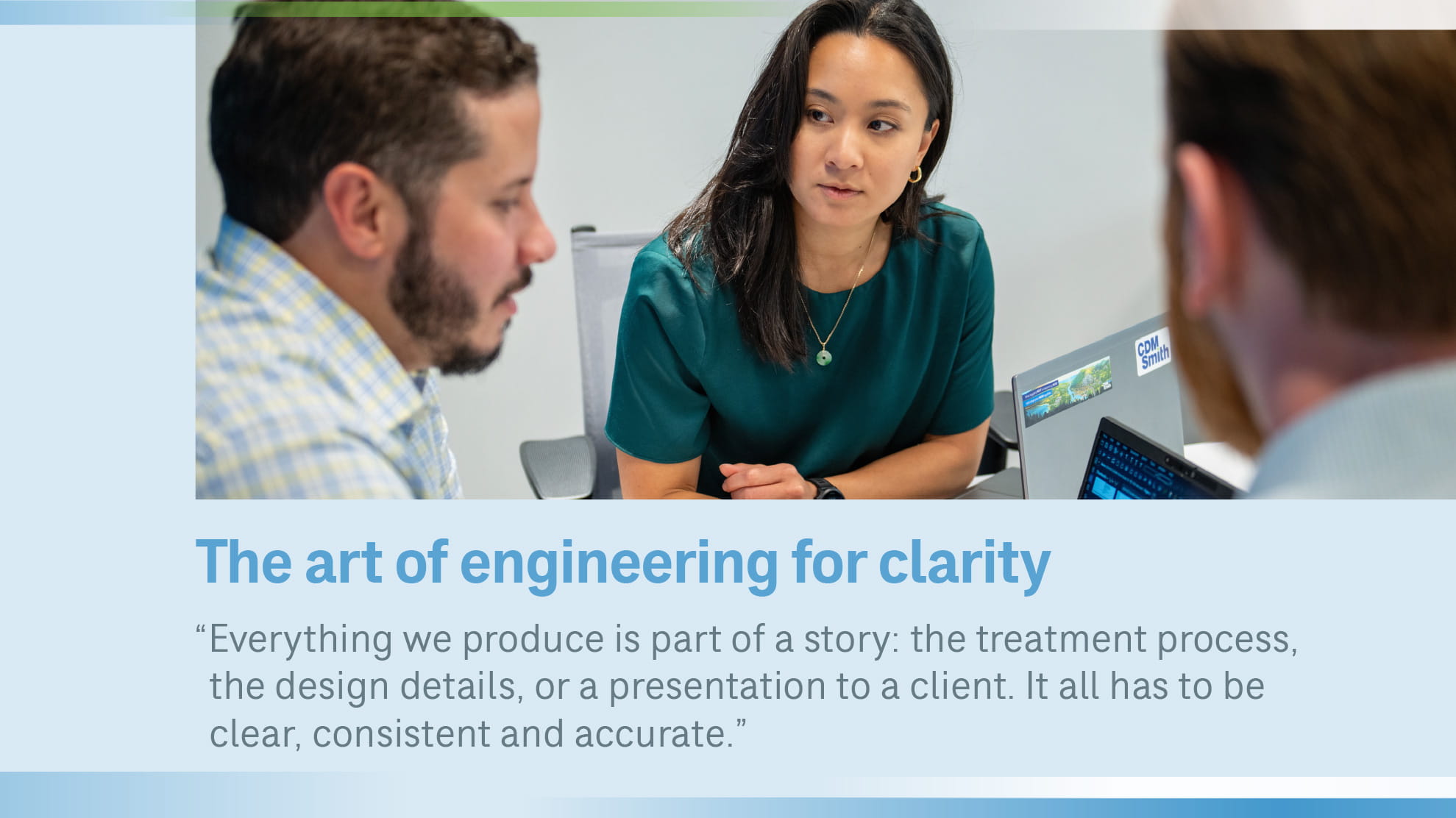 Young woman at desk talking to 2 men