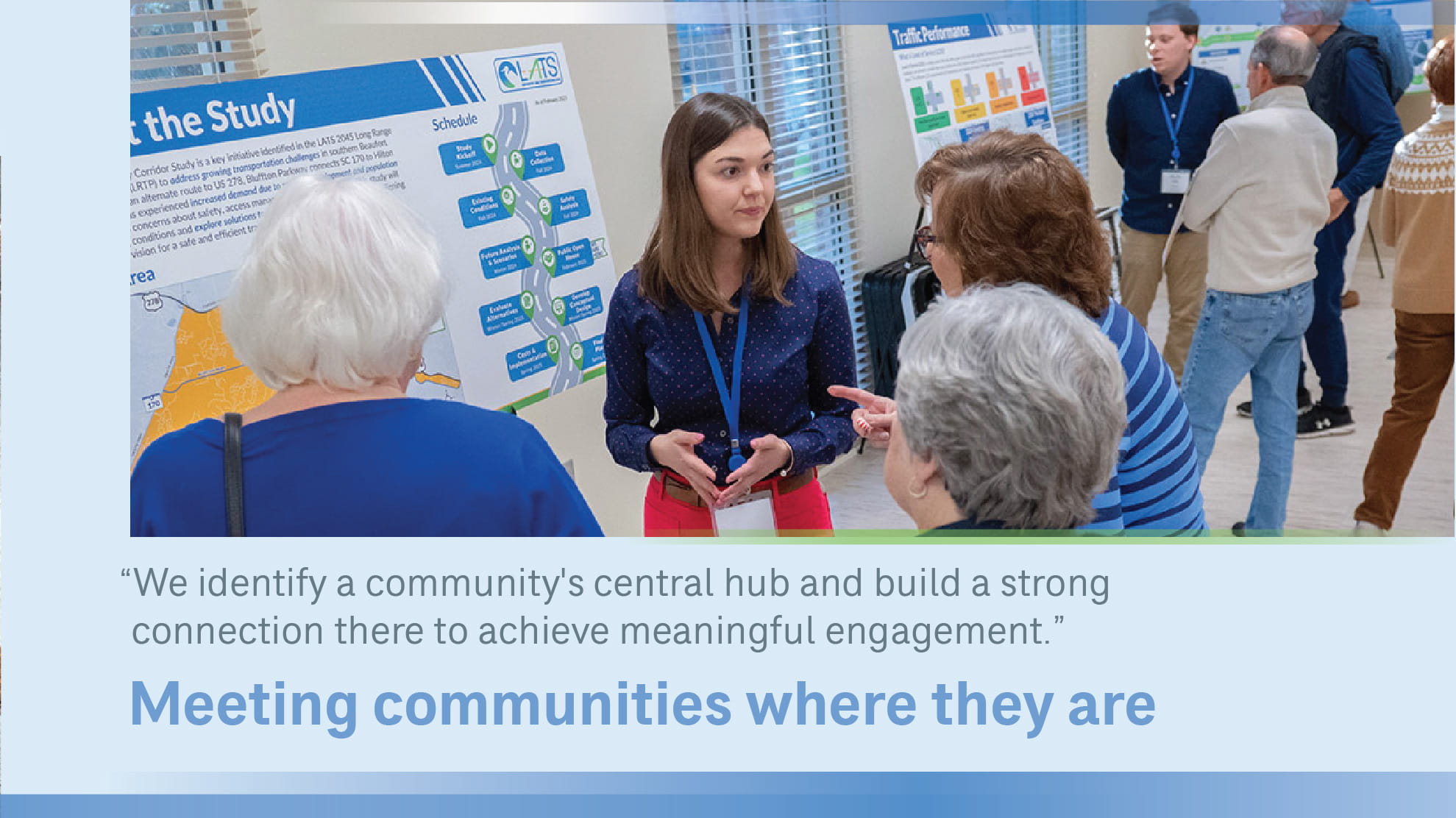 Victoria in front of a poster talking to people