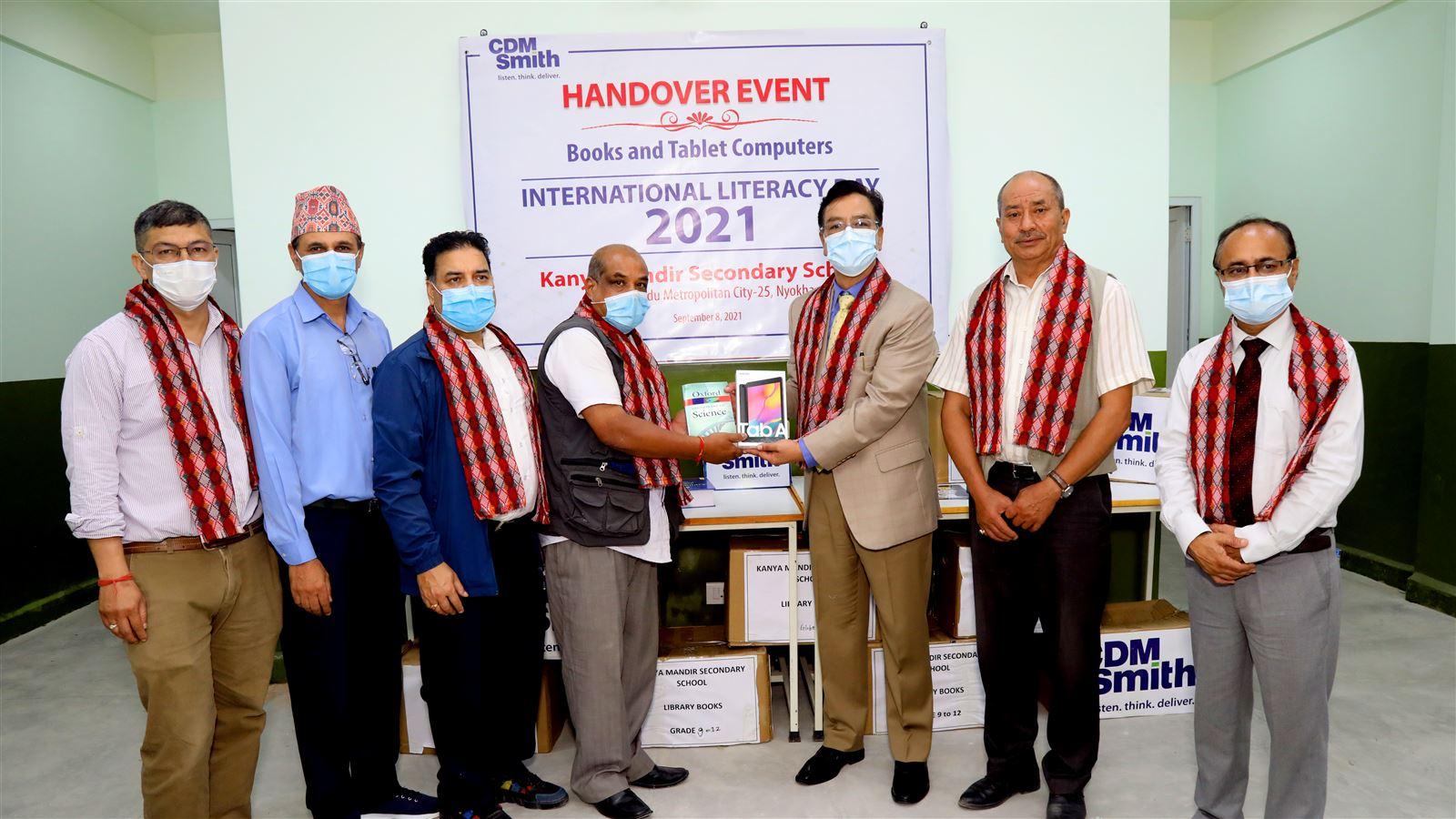 CDM Smith representatives hand over books and tablets at the Adarsha Secondary School, Bhaktapur.